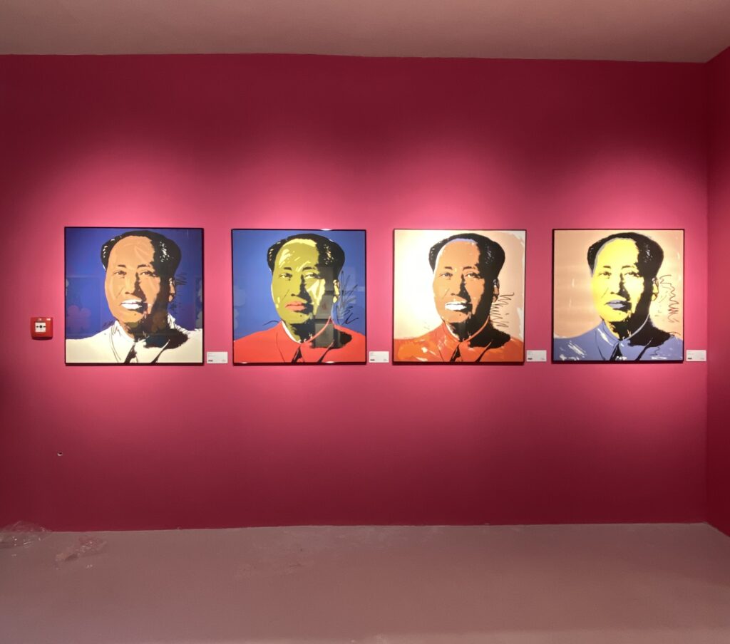 set of four Andy Warhol Mao silkscreen prints in different colourways on a pink gallery wall